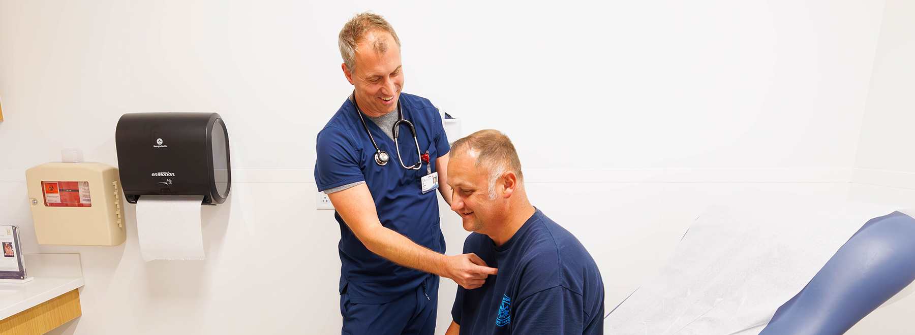 Cardiologist pointing to the chest of a patient in an exam room.